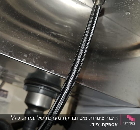 צינור מתכת מתחת לכיור עם חיבורים
